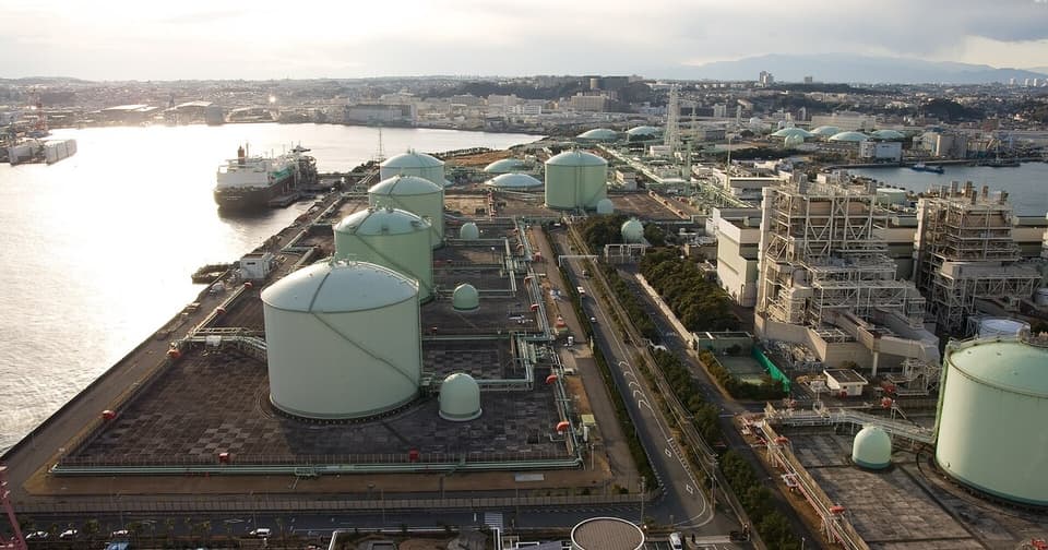 Aerial photo of a port showing large cylindrical LNG storage tanks and ships.
