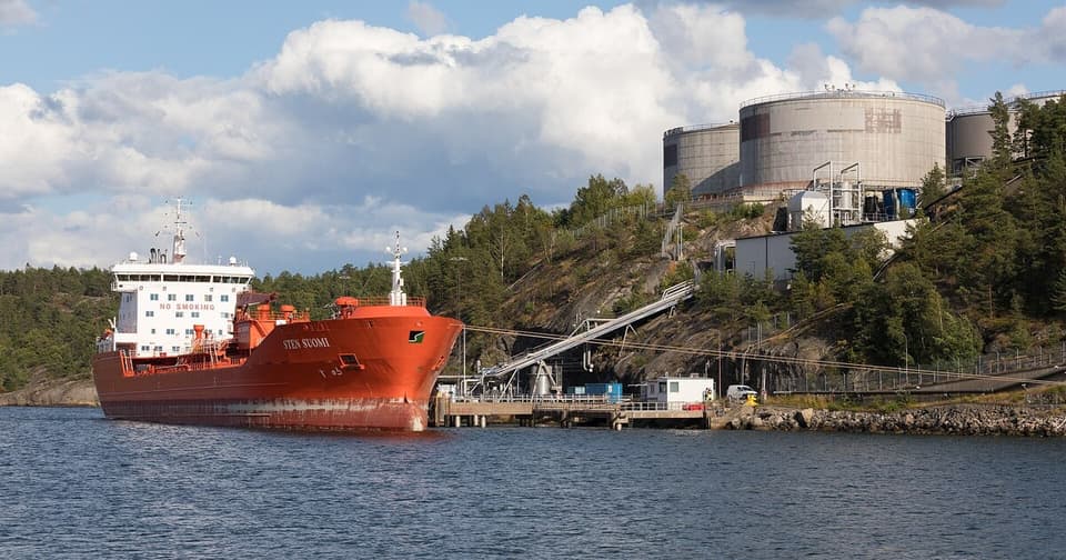 Limanında yükleme yapan kargo tanker gemisi ve depolama tankları