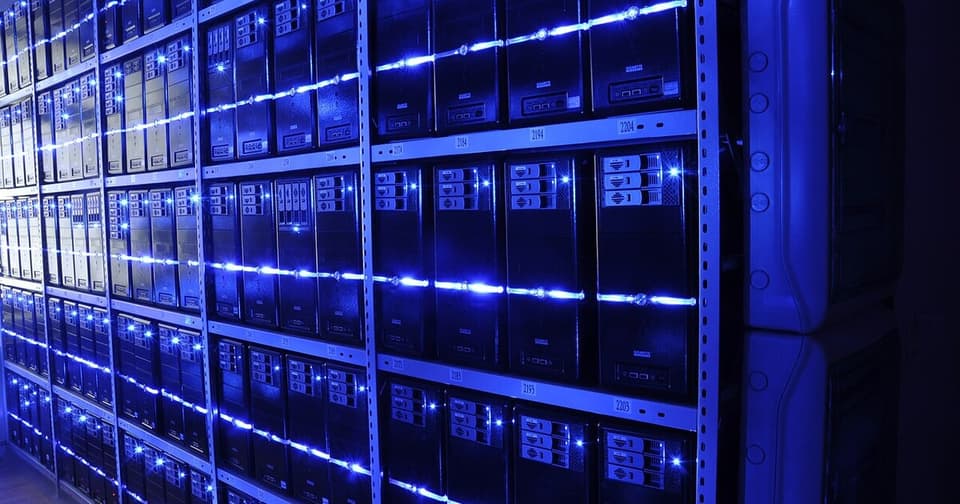 Data center server room, computer hardware arranged in rack systems with blue LED lighting