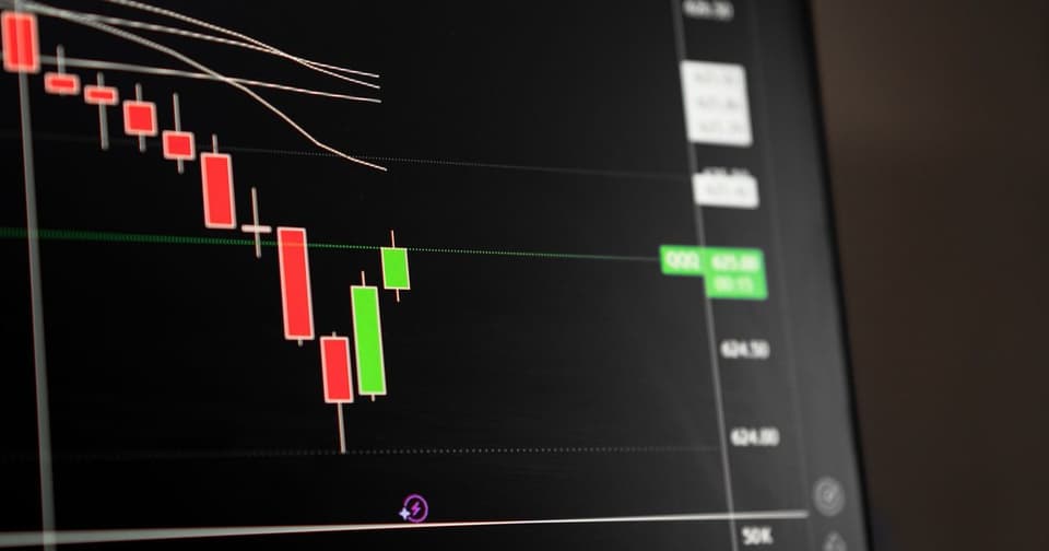 Candlestick chart on a dark screen with downward red candles followed by green candles
